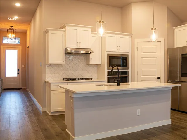 a kitchen with stainless steel appliances a stove and a refrigerator