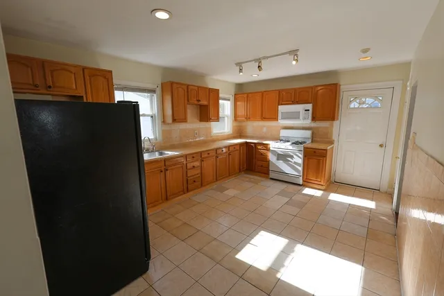 a kitchen with a sink a refrigerator and cabinets