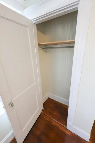 a view of walk in closet with wooden floor