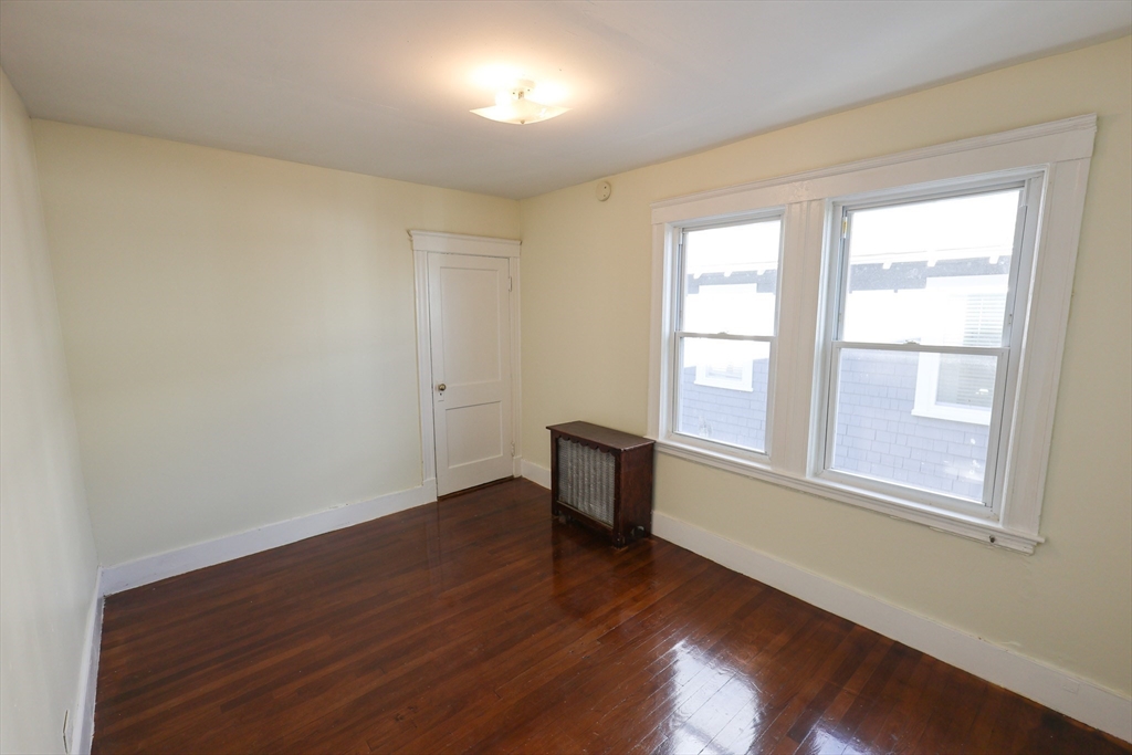 144 Blake Street, Unit 2 Boston, MA 02136 - Photo 20 of 28 an empty room with wooden floor and windows