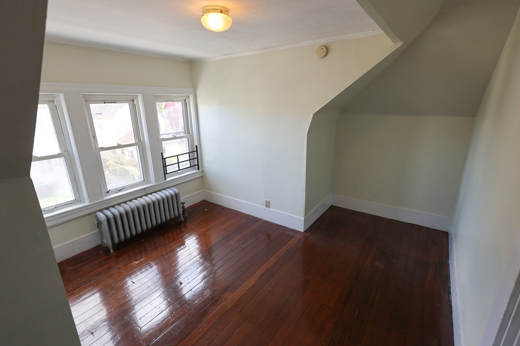 144 Blake Street, Unit 2 Boston, MA 02136 - Photo 21 of 28 an empty room with wooden floor and windows