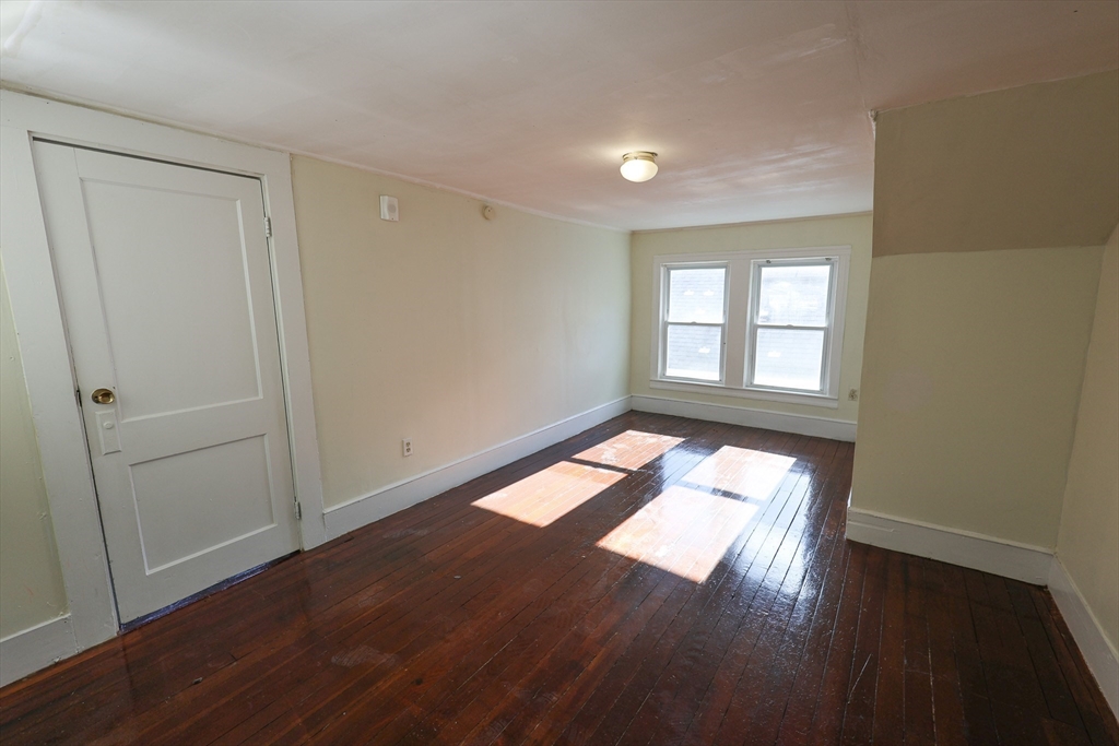 144 Blake Street, Unit 2 Boston, MA 02136 - Photo 24 of 28 an empty room with wooden floor and windows