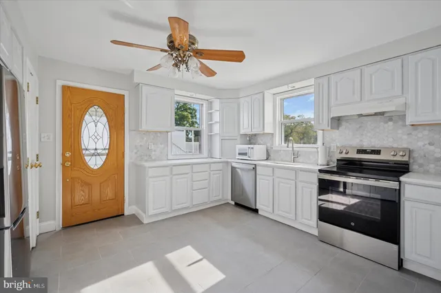 a kitchen with cabinets stainless steel appliances and a window