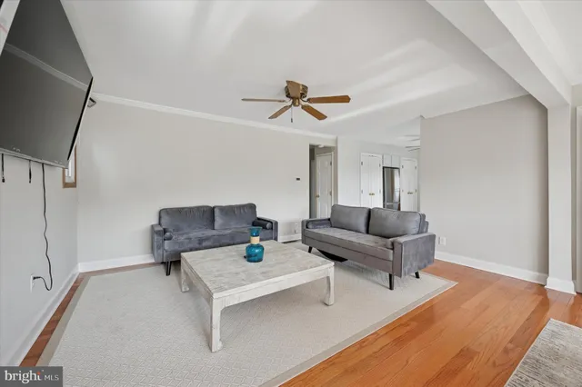 a living room with furniture and a ceiling fan