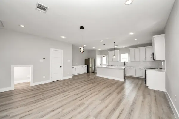 a large kitchen with stainless steel appliances granite countertop a lot of counter space and wooden floor