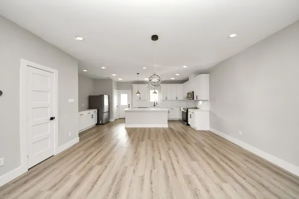 a view of a kitchen with kitchen island a sink dishwasher stove with wooden floor