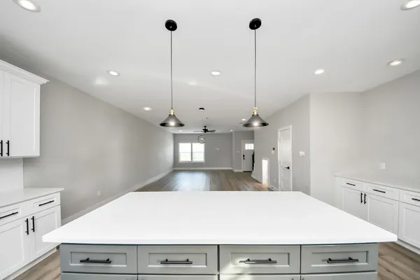 a view of a kitchen with a refrigerator a sink and wooden floor