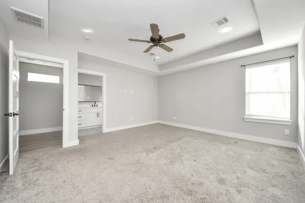 an empty room with a ceiling fan and window