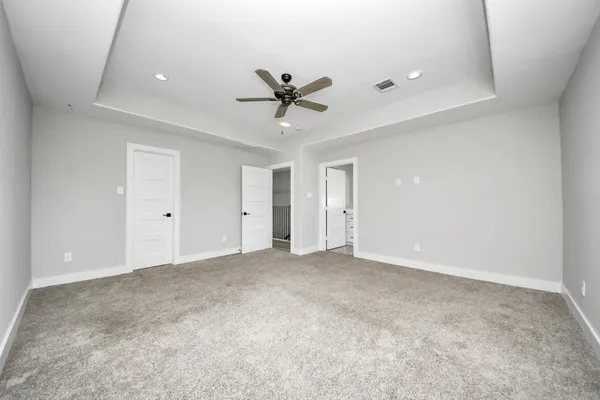 an empty room with closet and a ceiling fan
