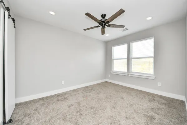 an empty room with window and ceiling fan