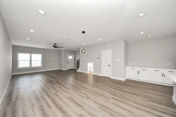 an empty room with wooden floor and windows