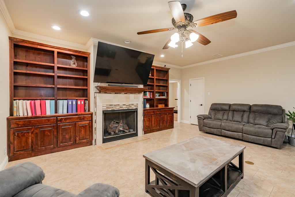 2687 McClendon Road Weatherford, TX 76088 - Photo 13 of 40 a living room with furniture a flat screen tv and a fireplace