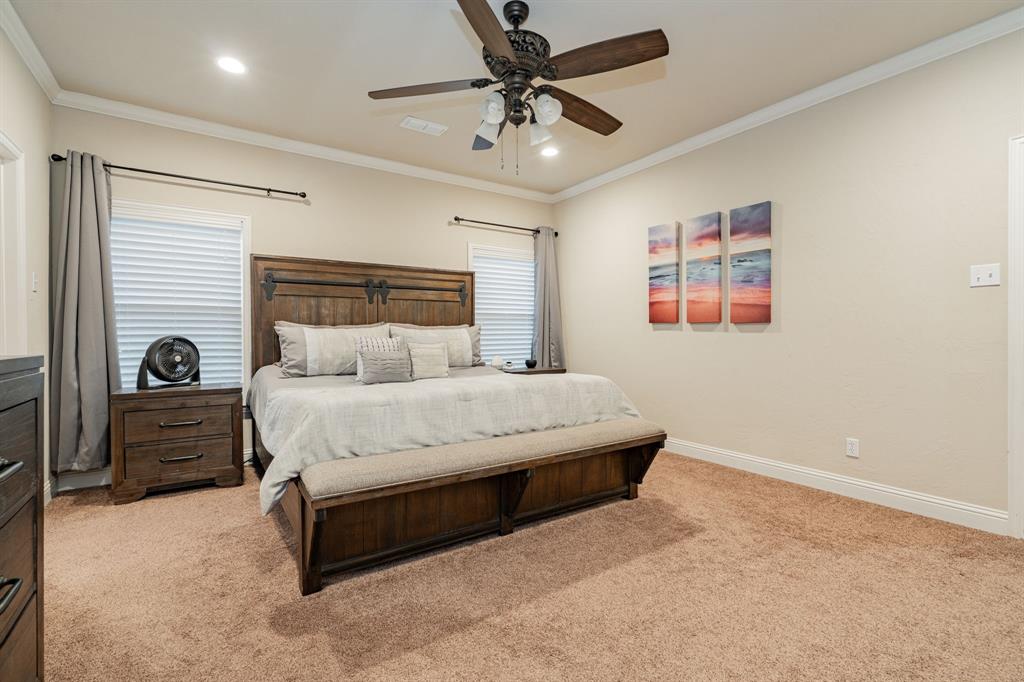 2687 McClendon Road Weatherford, TX 76088 - Photo 18 of 40 a bedroom with a bed a couch and a chandelier