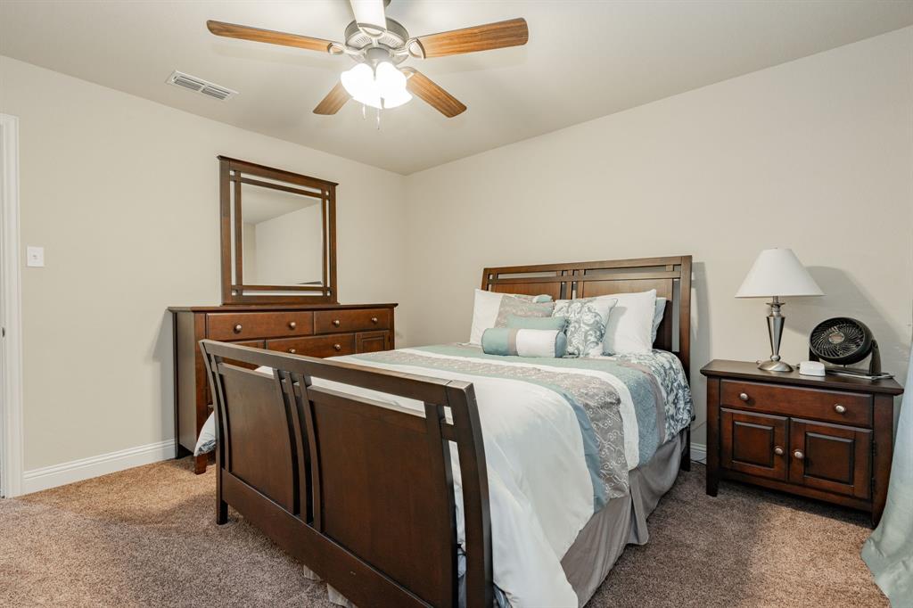 2687 McClendon Road Weatherford, TX 76088 - Photo 28 of 40 a bedroom with a bed and a chandelier