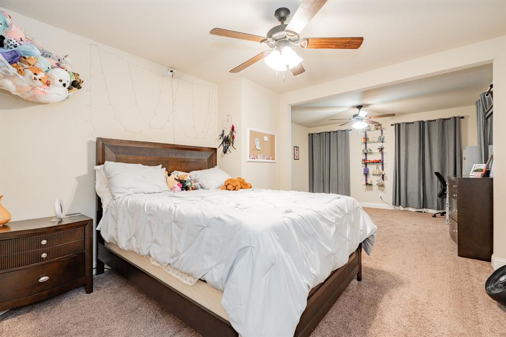 2687 McClendon Road Weatherford, TX 76088 - Photo 31 of 40 a bedroom with a bed and a chandelier