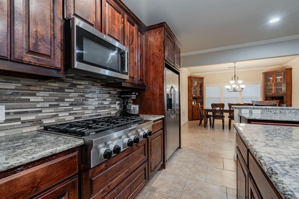 2687 McClendon Road Weatherford, TX 76088 - Photo 5 of 40 a kitchen with stainless steel appliances granite countertop a stove and a microwave
