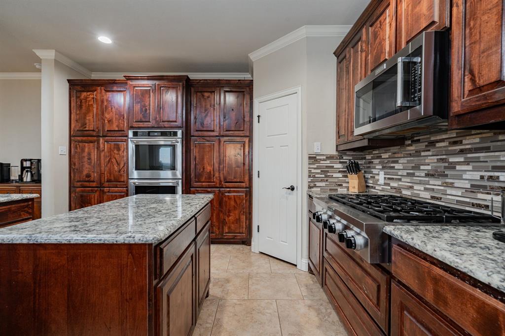2687 McClendon Road Weatherford, TX 76088 - Photo 7 of 40 a kitchen with granite countertop stainless steel appliances and wooden cabinets
