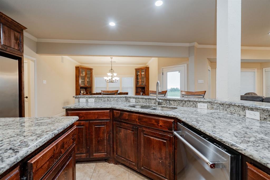 2687 McClendon Road Weatherford, TX 76088 - Photo 8 of 40 a kitchen with granite countertop cabinets sink and stove