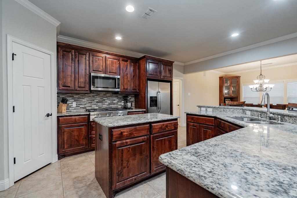 2687 McClendon Road Weatherford, TX 76088 - Photo 9 of 40 a kitchen with stainless steel appliances granite countertop wooden cabinets sink and stove