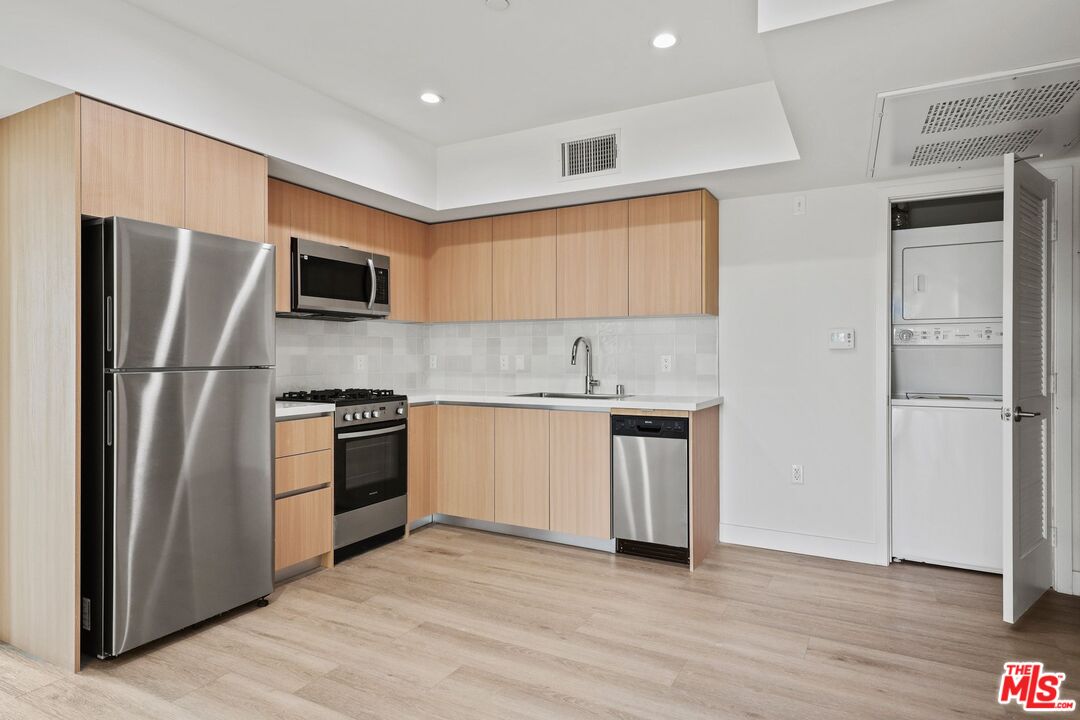 1600 Venice Blvd., Unit 102 Venice, CA 90291 - Photo 6 of 15 a kitchen with stainless steel appliances granite countertop a refrigerator and a stove top oven