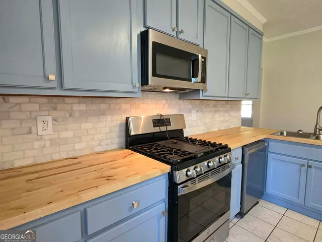a kitchen with granite countertop a stove and a microwave
