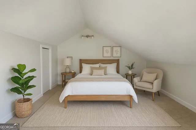 a bedroom with a bed a couch and a potted plant