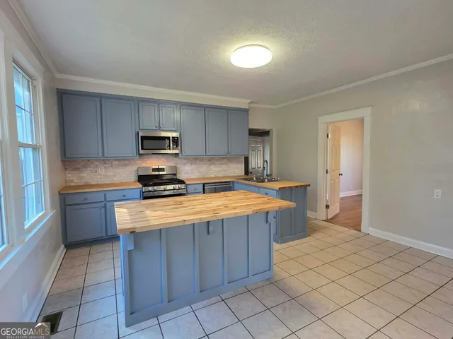 a kitchen with stainless steel appliances granite countertop a stove a sink and a refrigerator
