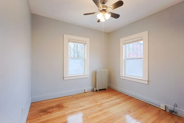 a view of an empty room with a window and closet area