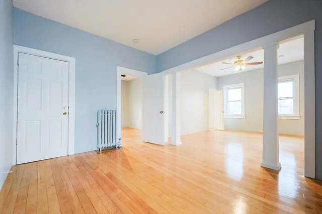 a view of empty room with wooden floor