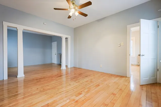 a view of an empty room with wooden floor