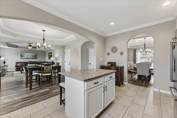 a kitchen with stainless steel appliances granite countertop a stove top oven a sink dishwasher and a refrigerator with wooden floor