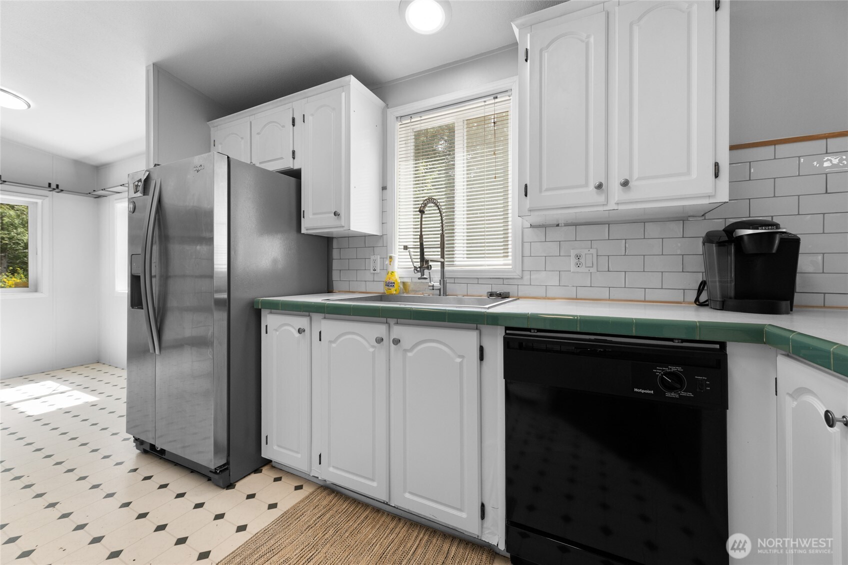 16037 Vail Loop Road Southeast Rainier, WA 98576 - Photo 6 of 32 a kitchen with granite countertop a refrigerator a sink and white cabinets