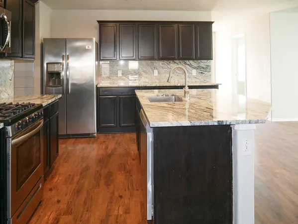 a kitchen with granite countertop a stove and cabinets