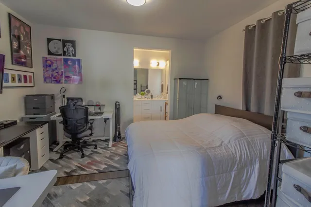 a bedroom with a bed a desk and chair