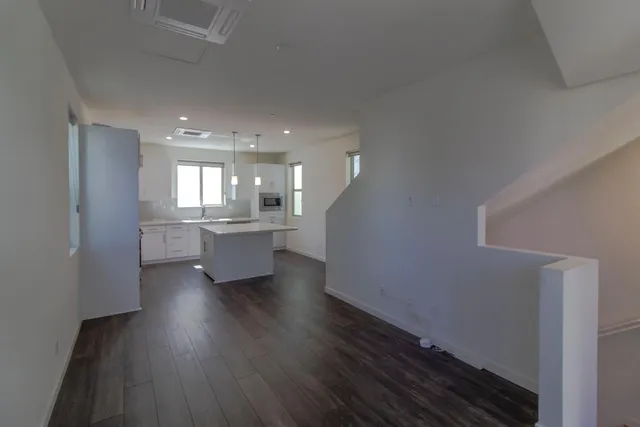 a view of kitchen and hall with wooden floor