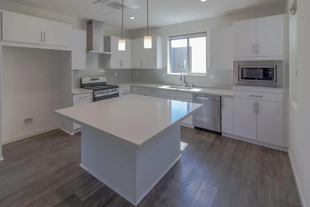 a kitchen with granite countertop a sink a stove and cabinets