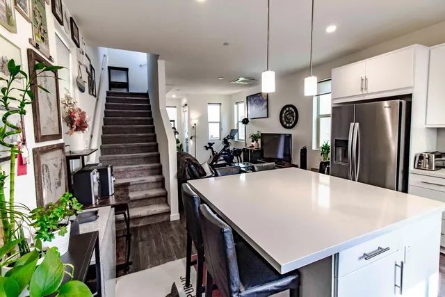 a large kitchen with stainless steel appliances a refrigerator a oven a sink a dining table and chairs