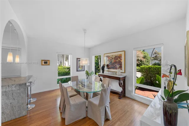 a dining room with furniture potted plants and wooden floor