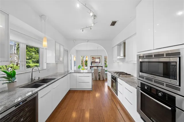 a large kitchen with a sink and stainless steel appliances