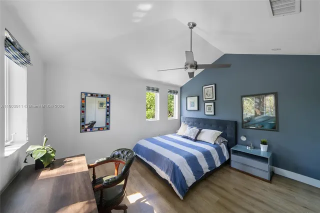 a bedroom with a bed mirror and a window