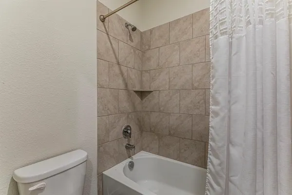 a bath room with a toilet and a bath tub