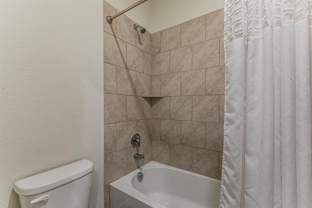 217 Watson Street Red Oak, TX 75154 - Photo 20 of 26 a bath room with a toilet and a bath tub