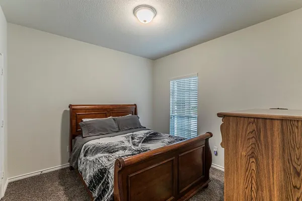 a bed sitting in a bedroom next to a window