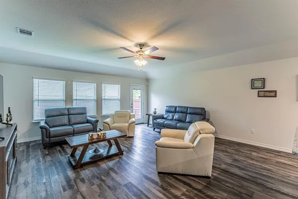 a living room with furniture and wooden floor