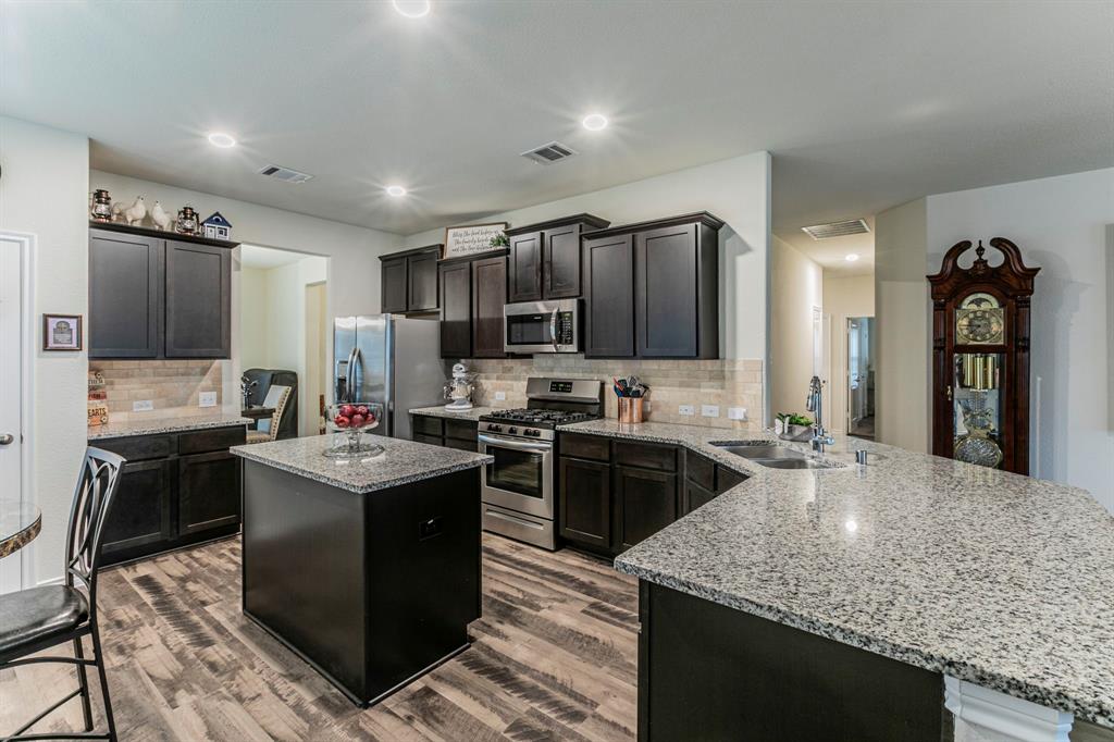 217 Watson Street Red Oak, TX 75154 - Photo 8 of 26 a kitchen with kitchen island granite countertop a sink stove and refrigerator