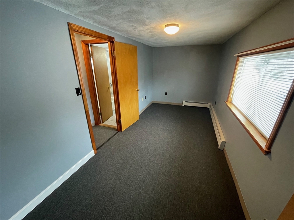 39 Franklin Street, Unit R Woburn, MA 01801 - Photo 12 of 18 wooden floor in an empty room with a window