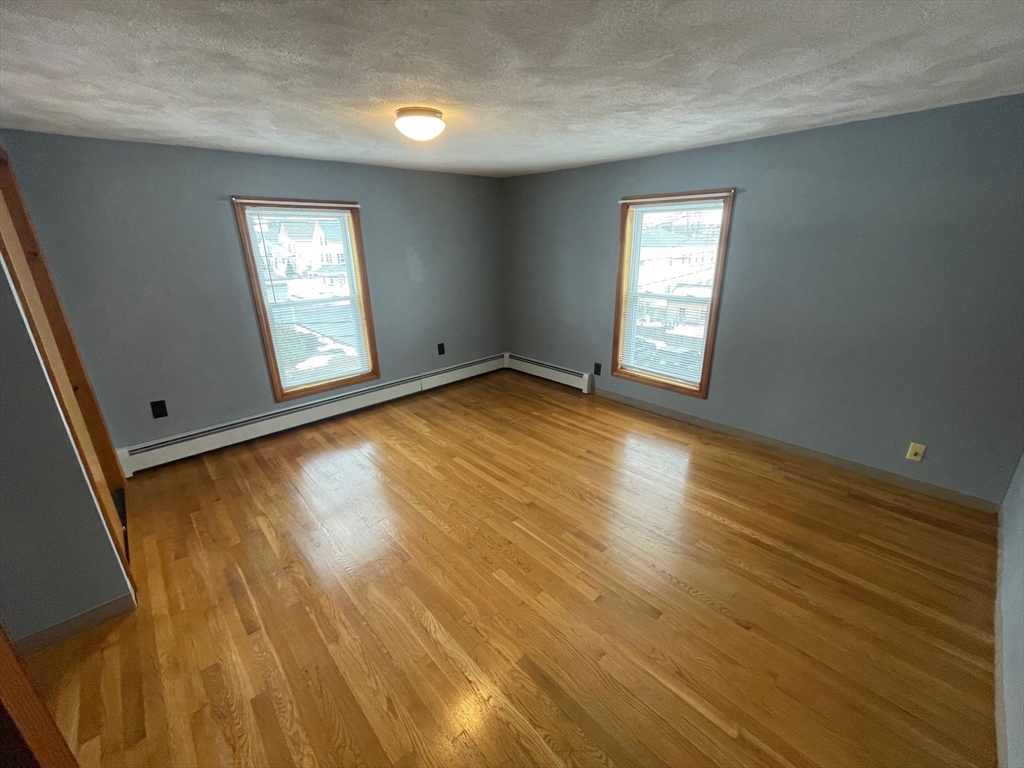 39 Franklin Street, Unit R Woburn, MA 01801 - Photo 15 of 18 a view of empty room with window and wooden floor