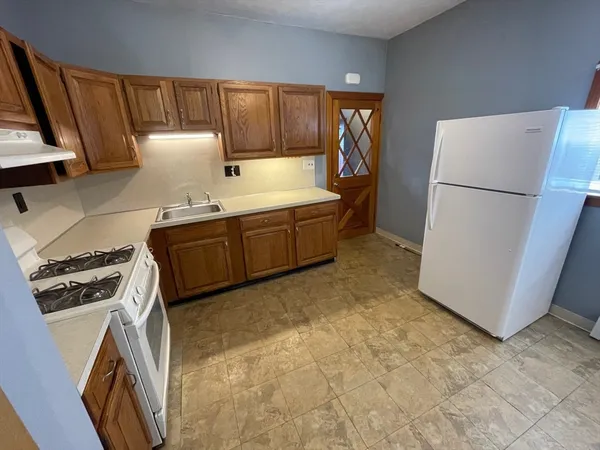 a kitchen with granite countertop a refrigerator a stove a sink a washer and dryer