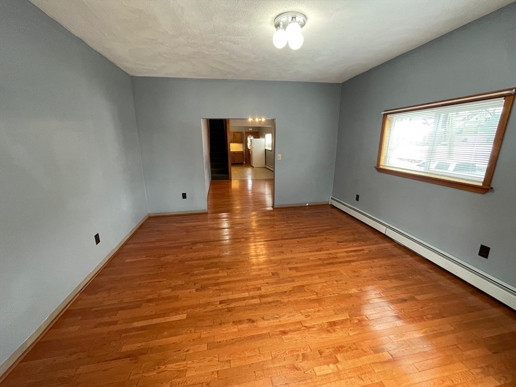 39 Franklin Street, Unit R Woburn, MA 01801 - Photo 8 of 18 an empty room with wooden floor and windows