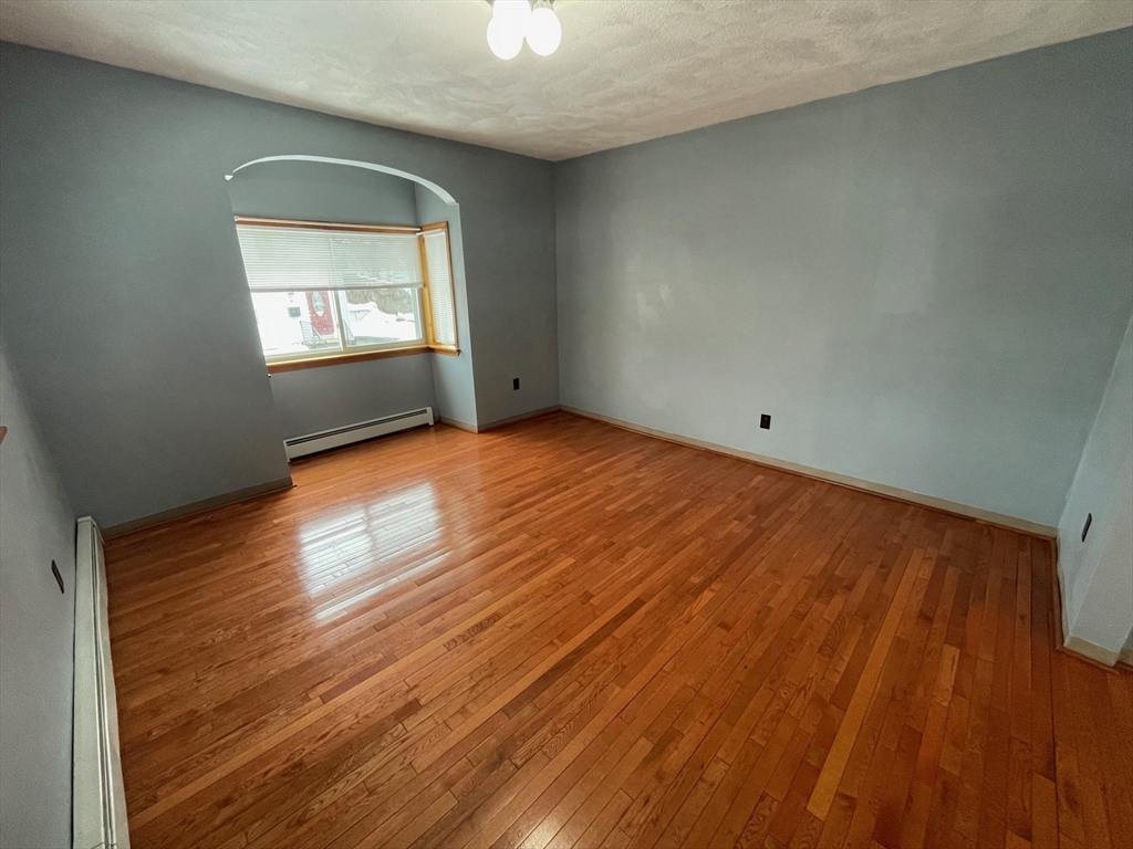 39 Franklin Street, Unit R Woburn, MA 01801 - Photo 9 of 18 an empty room with wooden floor cabinet and windows